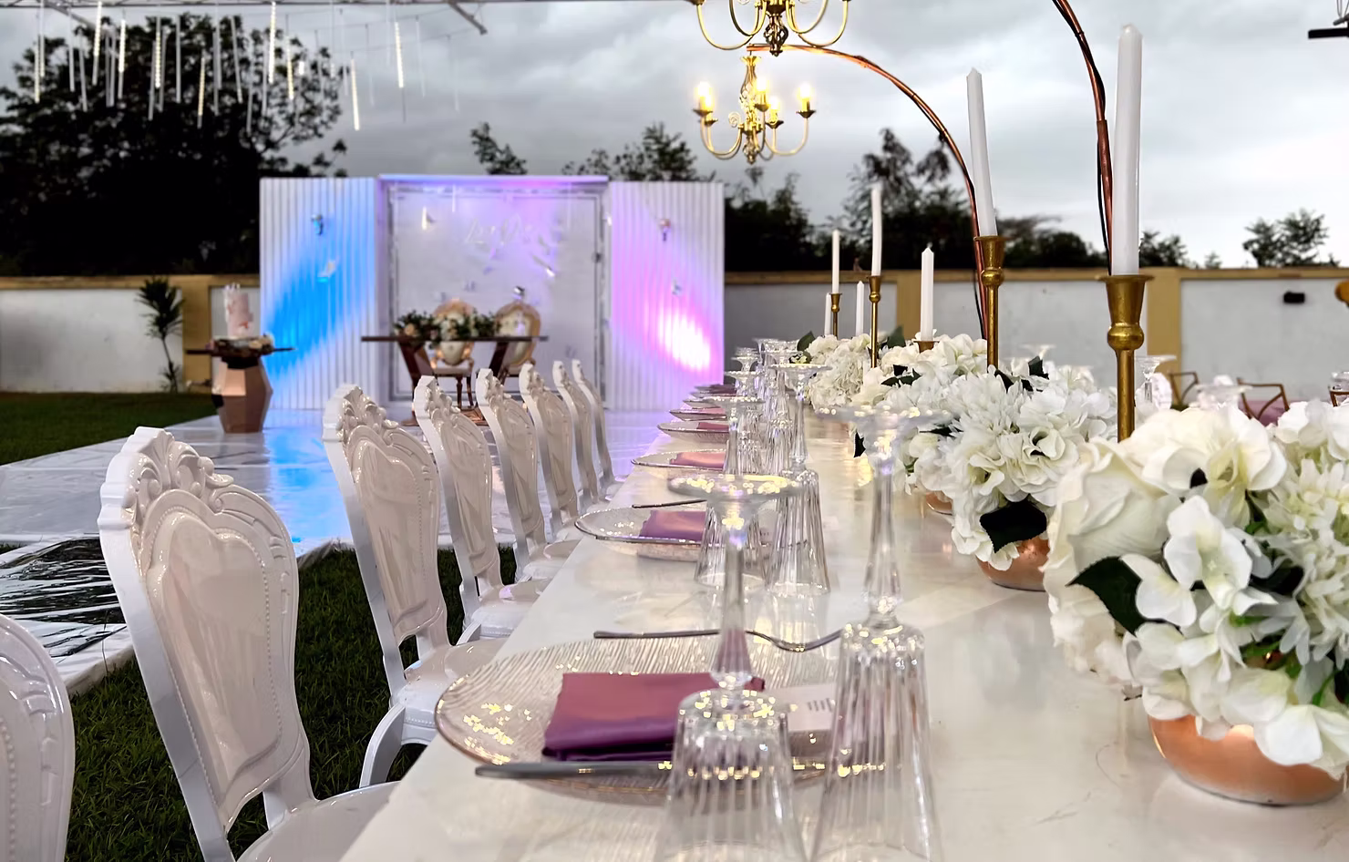 Outdoor reception table set with white flowers and candles