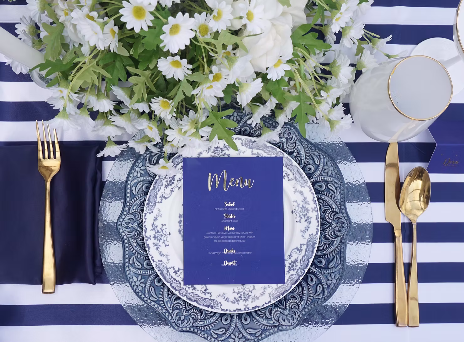 Blue-and-white place setting with flowers and gold cutlery
